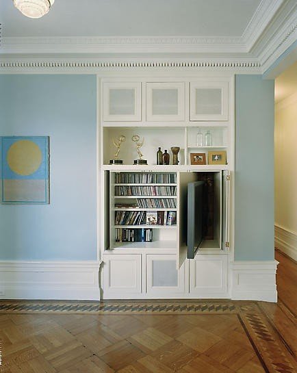 A compartment in this built-in shelving unit allows the TV to be tucked out of sight when not in use. Meanwhile, screened cabinet doors hide cable boxes, DVRs, and such without getting in the way of the remote signal.
Source
A compartment in this built-in shelving unit allows the TV to be tucked out of sight when not in use. Meanwhile, screened cabinet doors hide cable boxes, DVRs, and such without getting in the way of the remote signal.
Source