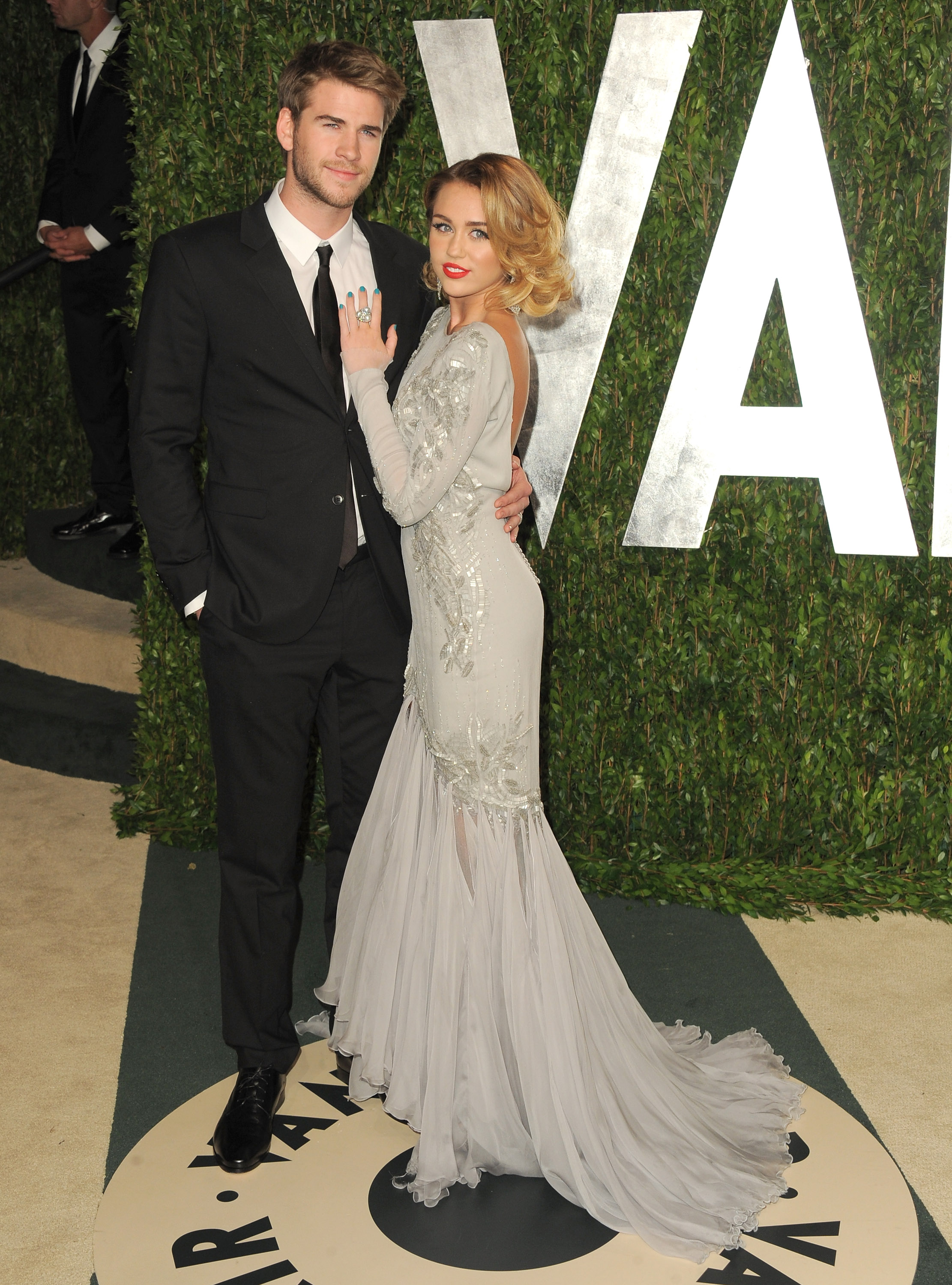 Miley holds on to her man Liam at the Vanity Fair party. Miley holds on to her man Liam at the Vanity Fair party.