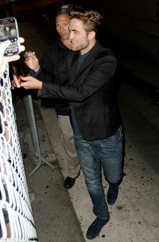 Robert Pattinson smiled and signed autographs for fans. Robert Pattinson smiled and signed autographs for fans.