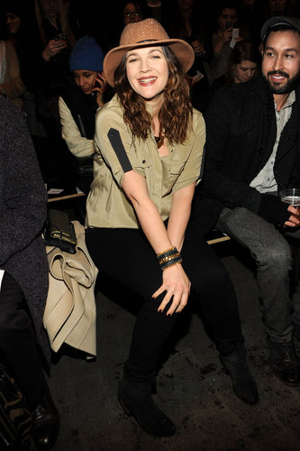 Drew Barrymore smiled wide in a silky olive blouse, brown hat, and CC Skye cuff while sitting front row at Rag & Bone.
Drew Barrymore smiled wide in a silky olive blouse, brown hat, and CC Skye cuff while sitting front row at Rag & Bone.