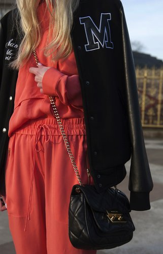 A low-slung crossbody bag graced effortlessly over an orange jumpsuit.
A low-slung crossbody bag graced effortlessly over an orange jumpsuit.
