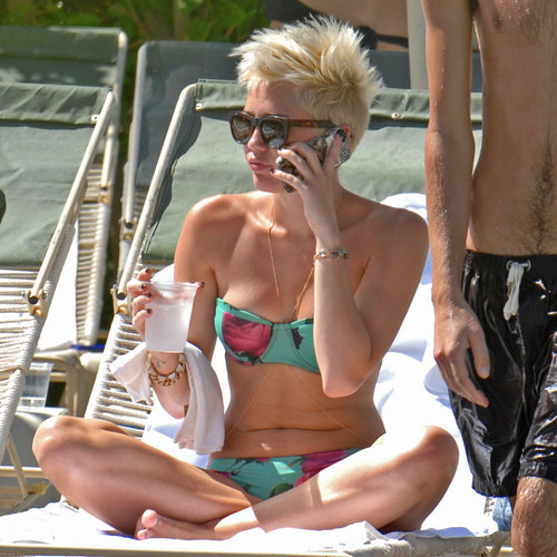 In March, Miley Cyrus lounged poolside in Palm Springs, showing off her svelte figure in a floral bikini, accessorized with gold body jewelry.
In March, Miley Cyrus lounged poolside in Palm Springs, showing off her svelte figure in a floral bikini, accessorized with gold body jewelry.