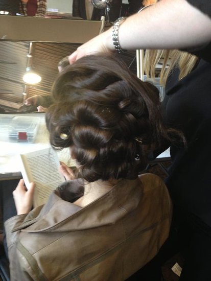 The foundation of the low chignon for the Monique Lhuillier bridal runway was a head full of bountiful curls. First, Nina Dimachki, lead hairstylist for Kérastase, applied a potion of Volumactive Mousse, Volumactive Spray, and Ciment Thermique. She then blow-dried hair before curling with a large iron and pinning up curls while still warm.
The foundation of the low chignon for the Monique Lhuillier bridal runway was a head full of bountiful curls. First, Nina Dimachki, lead hairstylist for Kérastase, applied a potion of Volumactive Mousse, Volumactive Spray, and Ciment Thermique. She then blow-dried hair before curling with a large iron and pinning up curls while still warm.