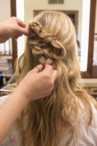 Be certain to grab some hair from the right and pin it along with the braided shape to form a half-up style. Then, secure the braids into place.
Be certain to grab some hair from the right and pin it along with the braided shape to form a half-up style. Then, secure the braids into place.