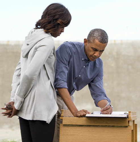 First Lady Michelle Obama looked on as President Obama signed a guest book in the Robben Island prison yard outside Cape Town, South Africa, in June.
First Lady Michelle Obama looked on as President Obama signed a guest book in the Robben Island prison yard outside Cape Town, South Africa, in June.
