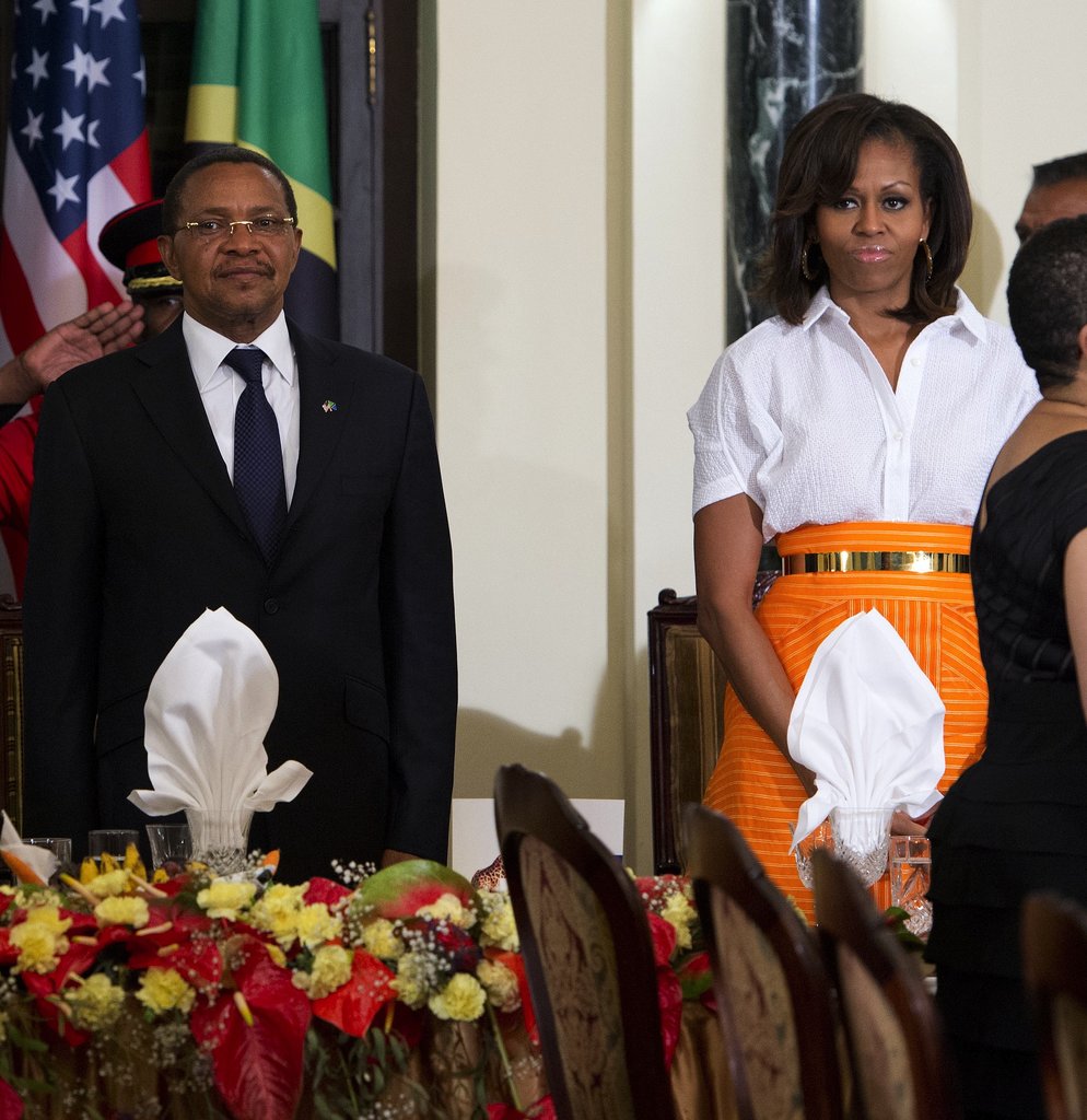During an official dinner in Tanzania, Michelle Obama tucked a crisp white short-sleeved Zero + Maria Cornejo blouse into a striped orange skirt, then added shine via a gold belt and hoop earrings.
During an official dinner in Tanzania, Michelle Obama tucked a crisp white short-sleeved Zero + Maria Cornejo blouse into a striped orange skirt, then added shine via a gold belt and hoop earrings.