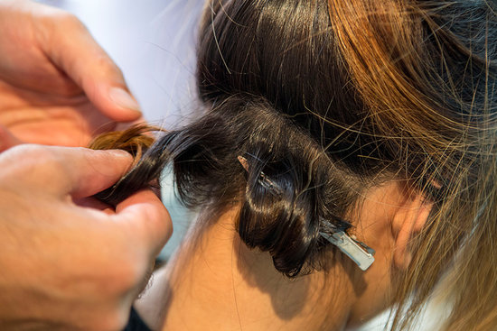After you've curled a section with the curling iron, create a pin curl using a duck bill clip to set the look.
After you've curled a section with the curling iron, create a pin curl using a duck bill clip to set the look.