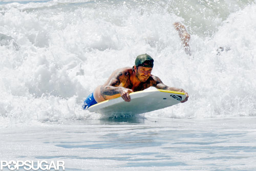 David Beckham surfed the waves on his boogie board.
David Beckham surfed the waves on his boogie board.