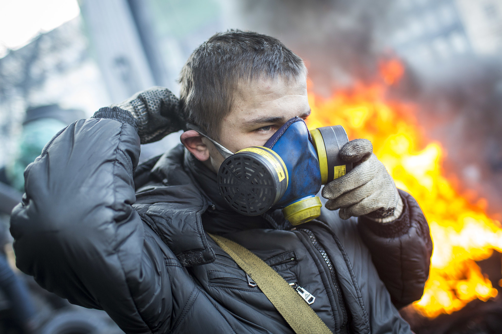 A protester put on his gas mask near the burning piles. You Can't