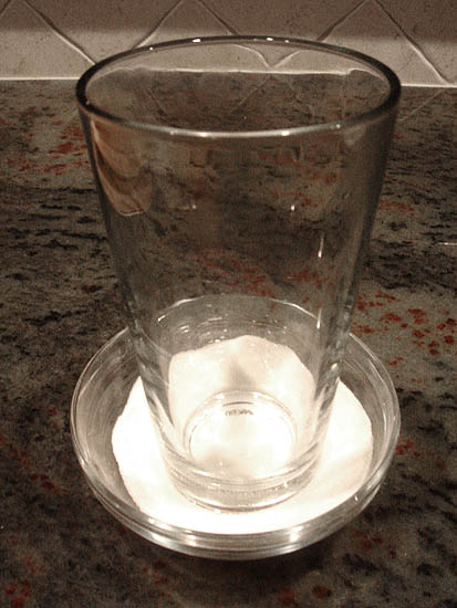 Dipping the bottom of a glass in sugar to prevent sticking to the cookie dough balls. Dipping the bottom of a glass in sugar to prevent sticking to the cookie dough balls.
