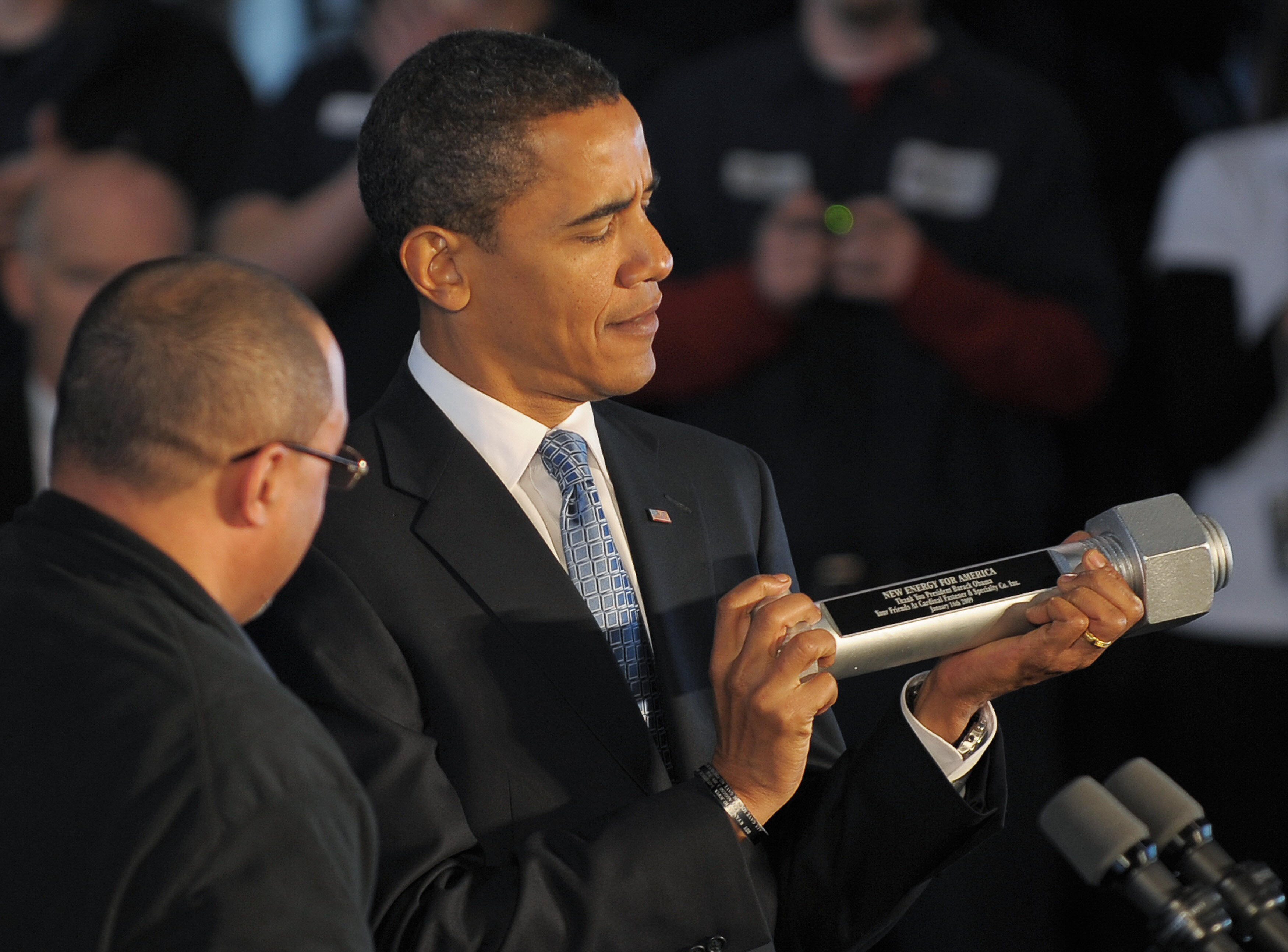 Obama holds a souvenir bolt presented to him by an employee following the tour. Obama holds a souvenir bolt presented to him by an employee following the tour.