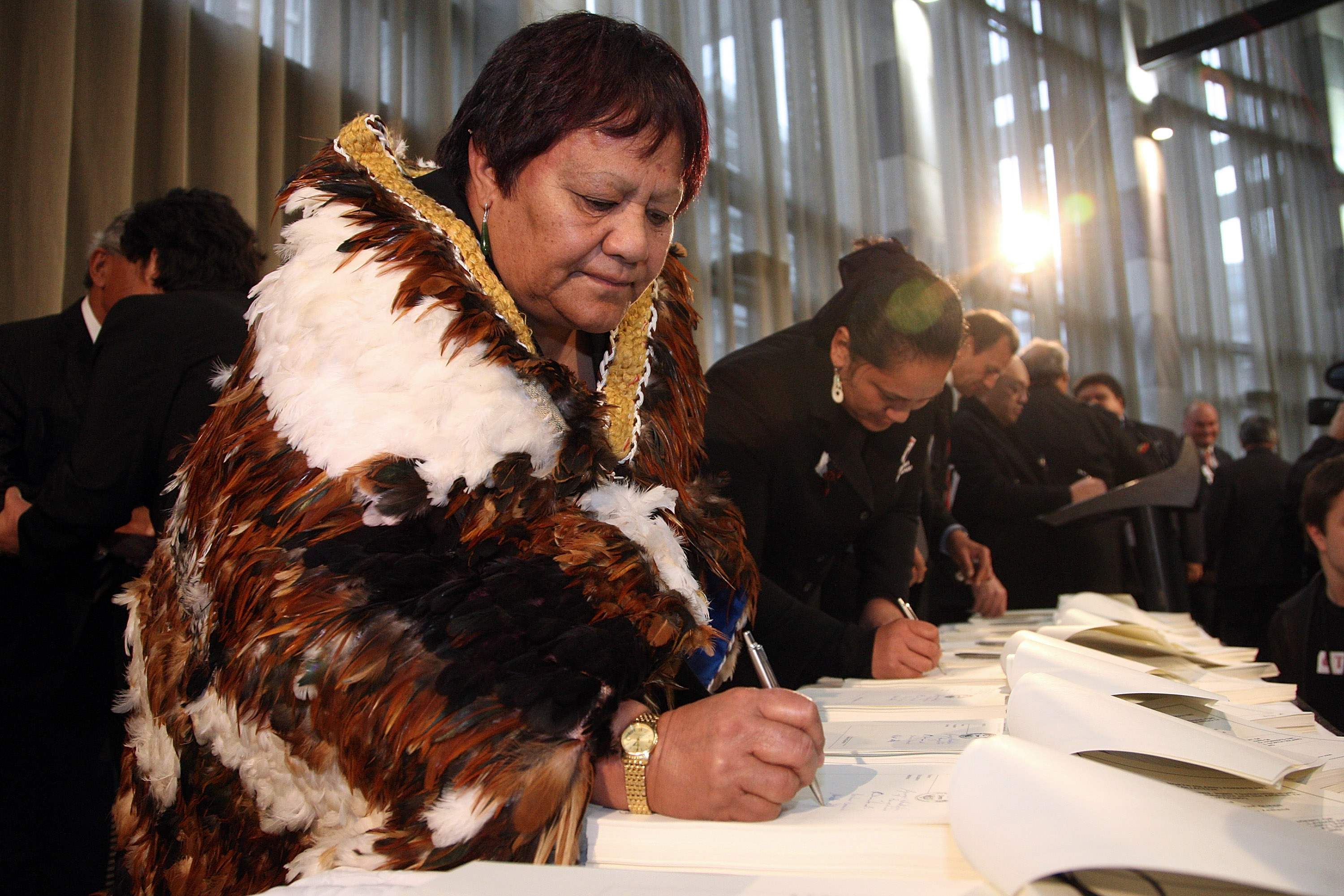 Iwi representatives sign documents. Iwi representatives sign documents.