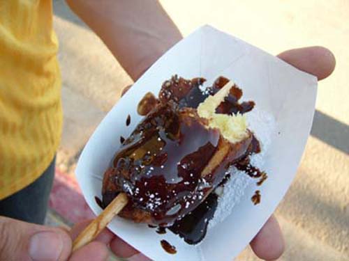 Deep-fried Twinkie On A Stick Dipped In Chocolate Syrup Deep-fried Twinkie On A Stick Dipped In Chocolate Syrup